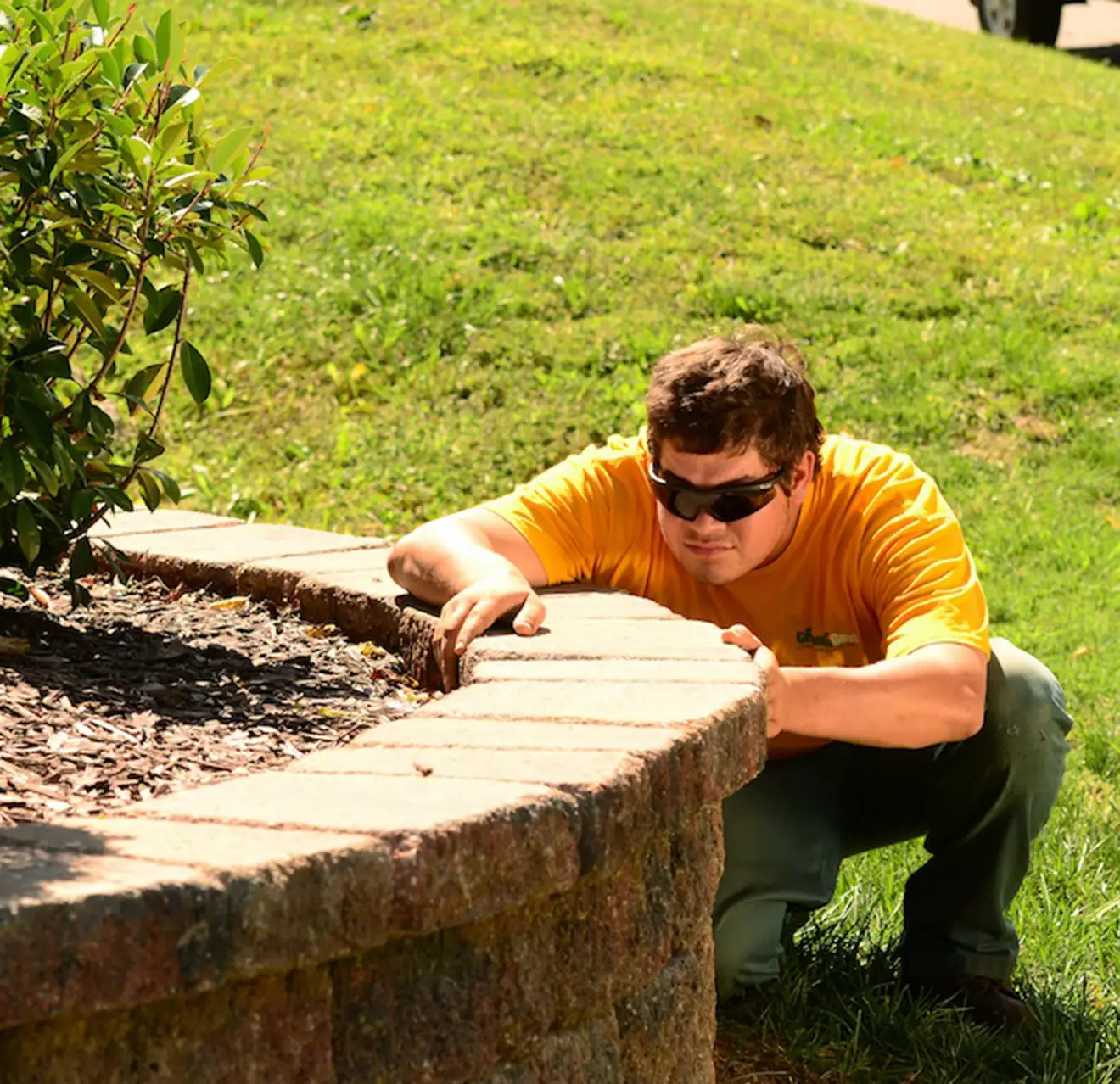 The Grounds Guys service professional installing pavers.