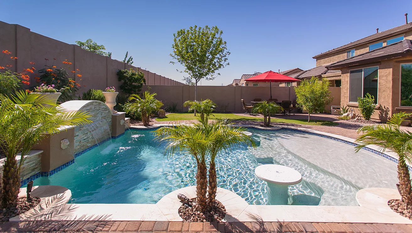 A beautiful inground pool with lush landscaping.