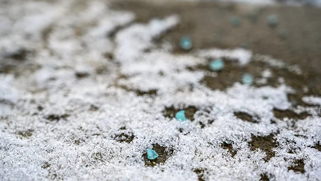 Salt, ice, and snow on a dirt pathway.