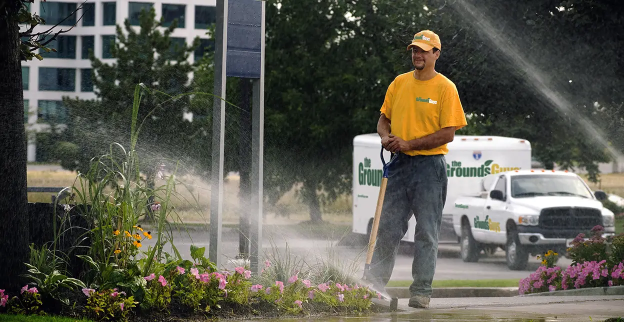 A man installing sprinkler on a lawn.