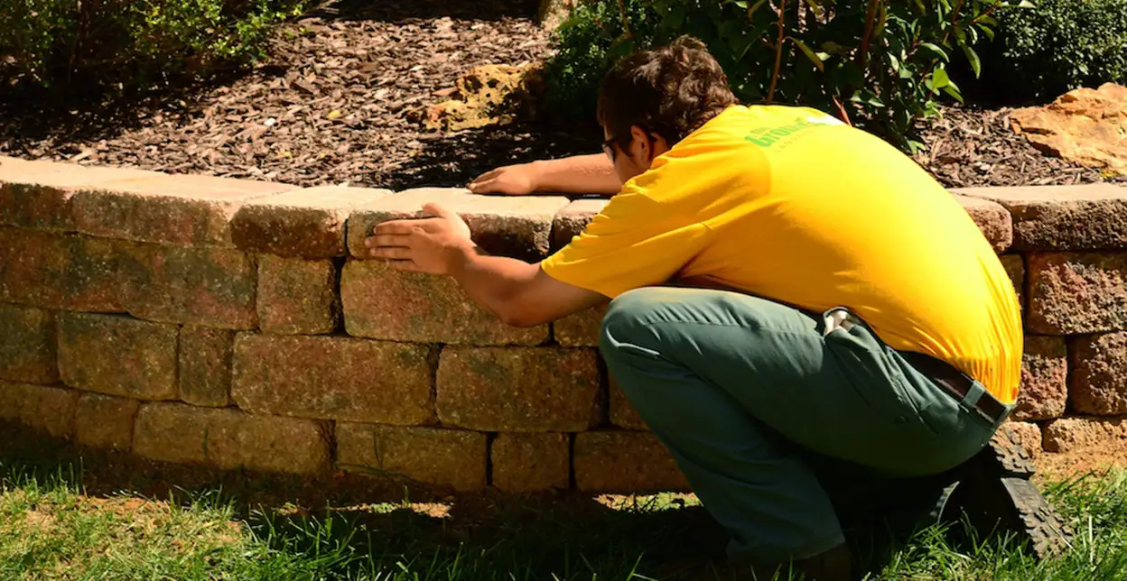 GUY technician installing a paver wall.