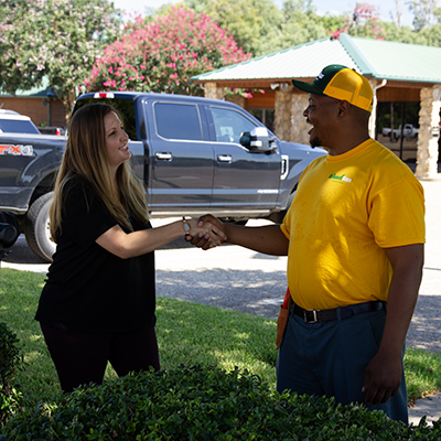 The Grounds Guys service professional shaking hands with a client.