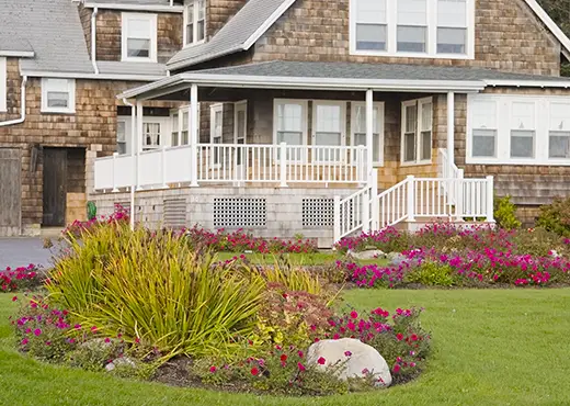 Flower beds in the front yard of a large home.