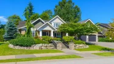 A large home with a well-landscape front yard.