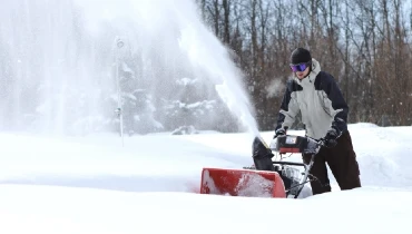 Man using a snowblower to clear snow