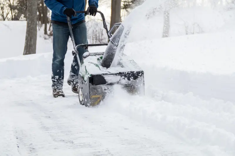 Landscaper using a snowblower