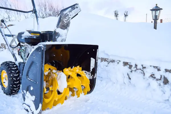 Snow blower on a driveway in the snow