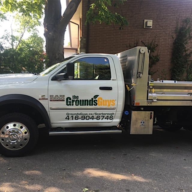 A Ground Guys work truck near a worksite.